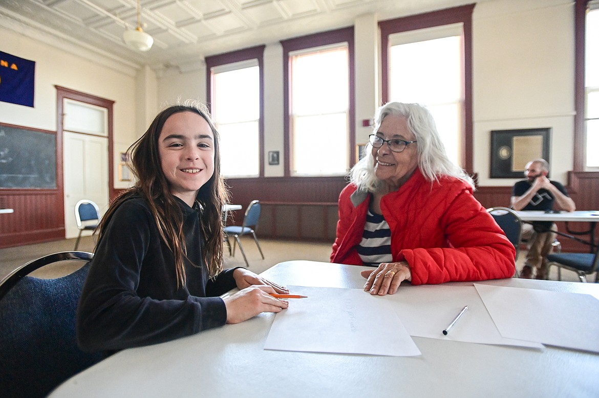 Ava Maynard writes an essay with Jacqueline Byers to be included in a time capsule during Central School's 130th anniversary party at the Northwest Montana History Museum on Friday, April 12. (Casey Kreider/Daily Inter Lake)