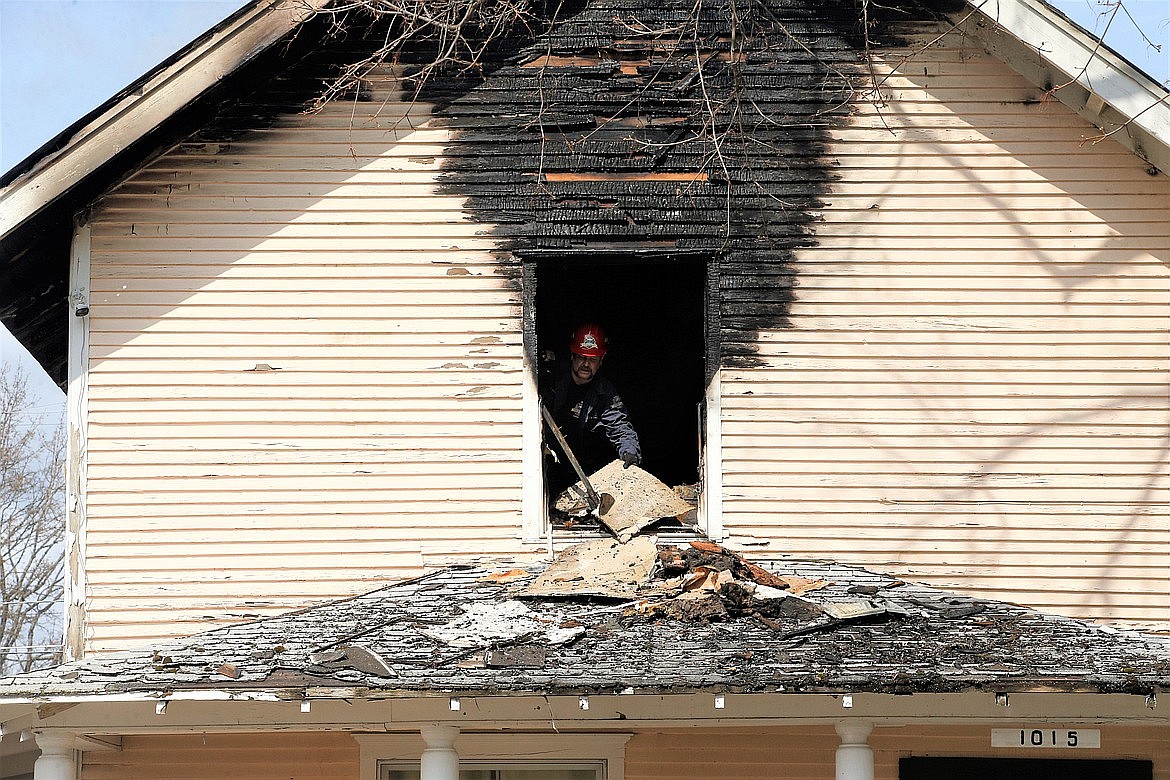 Coeur d'Alene Fire Department Deputy Fire Marshal Craig Etherton on April 14, 2023, moves material outside of the upstairs room of the Young Avenue home that was damaged in a fire the night before.