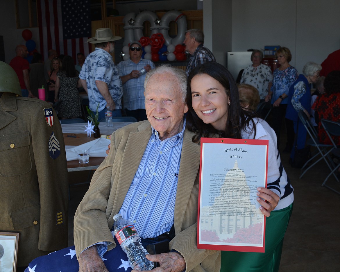 Natasha Jackson, Robert Gwin's granddaughter, secured a proclamation from the Idaho State Senate ahead of his 100th birthday. The two share a hug as she holds up the proclamation at his birthday party in Coeur d'Alene on Saturday.
