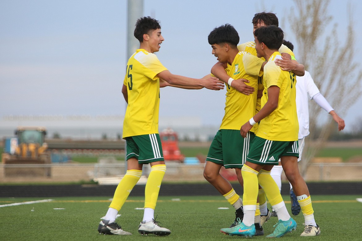 Quincy players celebrate with sophomore Ken Morales, center left, after Morales scored in the 10th minute against Chelan.