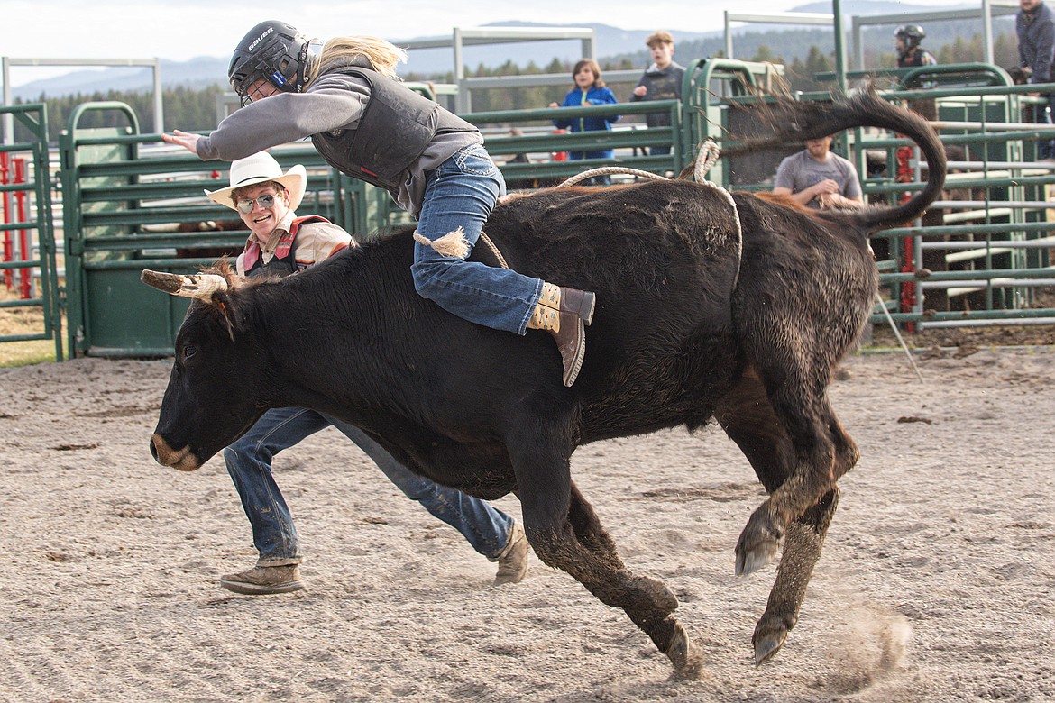 Korbin Baldwin (back) serves as bullfighter and coach for a young rider at Baldwin Bucking Bulls Friday, April 12.