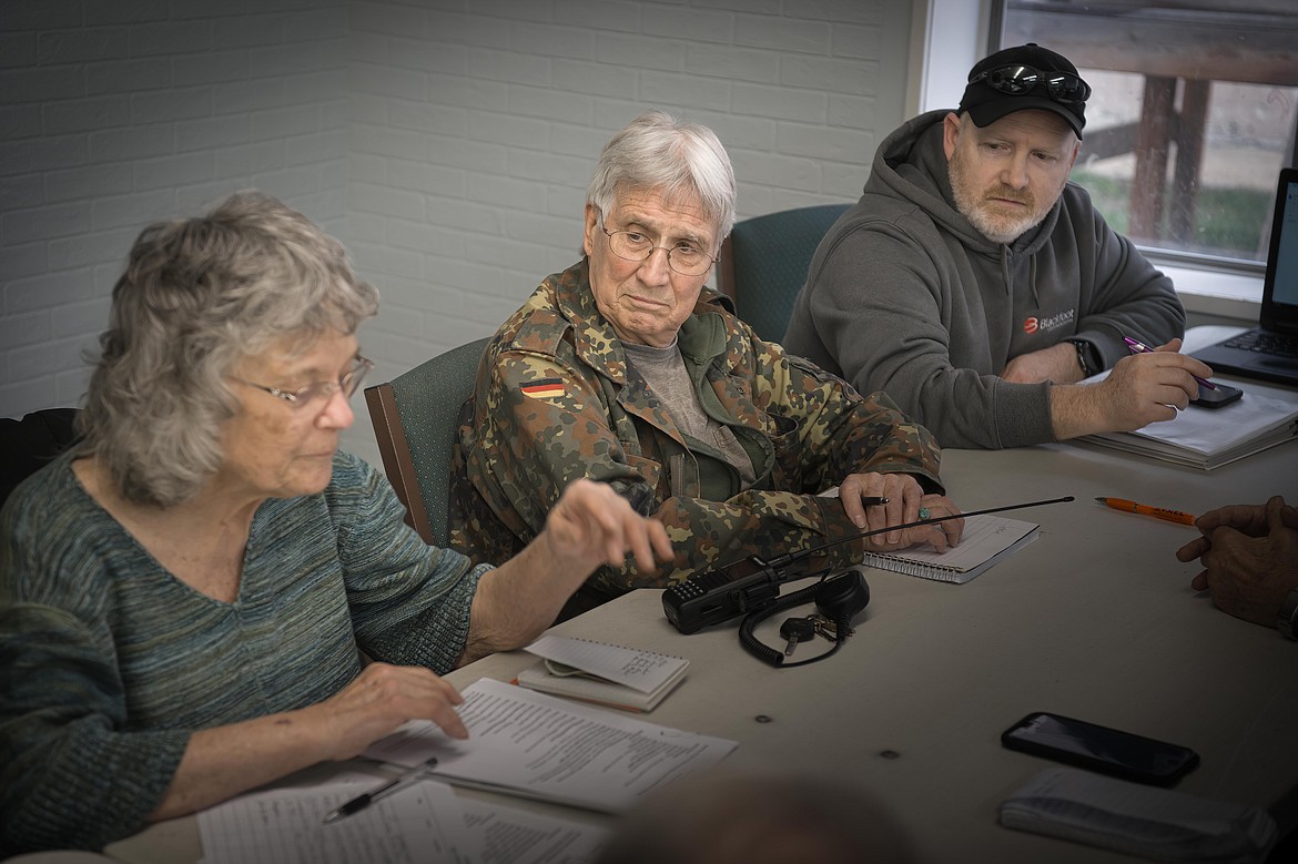 Clark Fork Valley Radio Club members Lyle Holoak, Bill Subda and Margaret Juneman discuss how they can help Sanders County with radio communications during emergency events. (Tracy Scott/Valley Press)