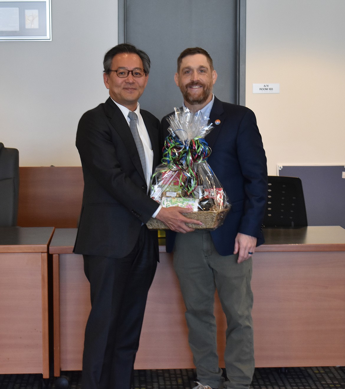 Moses Lake Mayor Dustin Swartz, right, presents Japanese Consul-General Makoto Iyori with a basket of Washington goodies, including wine, of which Iyori said he’s an aficionado.