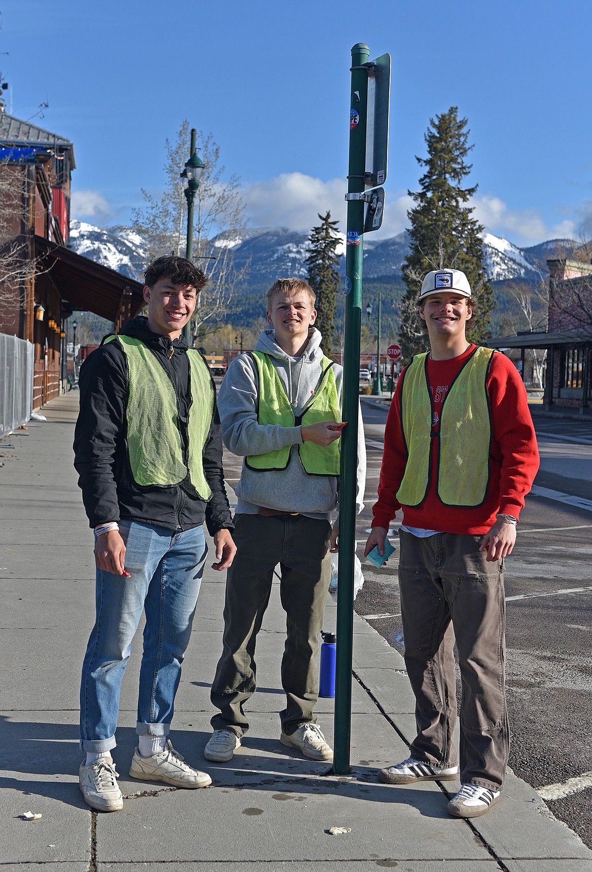 Ryder Barinowski, Buren Brust and Mason Genovese helped to remove stickers downtown along with nearly 90 other Whitefish high school seniors last week. (Julie Engler/Whitefish Pilot)
