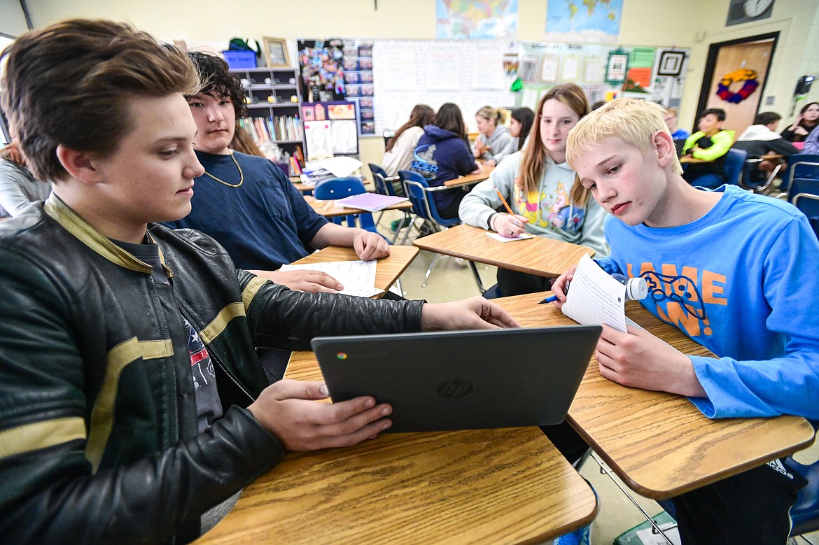 From left, Wyatt Buckallew, Jimmy Brown, Addy Keller and Bryce Woods read over their stories and illustrations created using artificial intelligence software in seventh-grade teacher Kristi Sanders' class at Kalispell Middle School on Tuesday, April 16. (Casey Kreider/Daily Inter Lake)