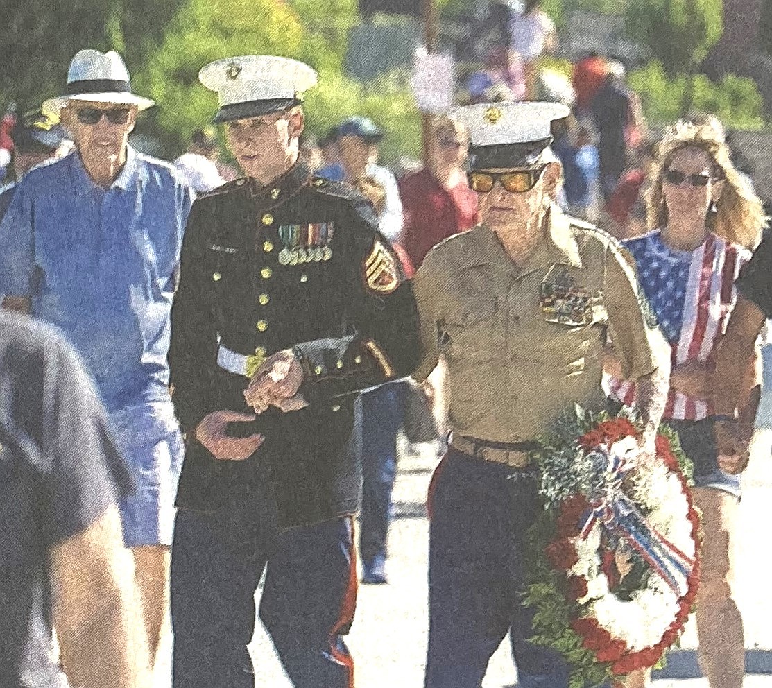 USMC Staff Sgt. Dustin Pfister assists Ray Garland, a decorated World War II and Korean War veteran, to the edge of Lake Coeur d’Alene to lay a wreath on Memorial Day 2018.