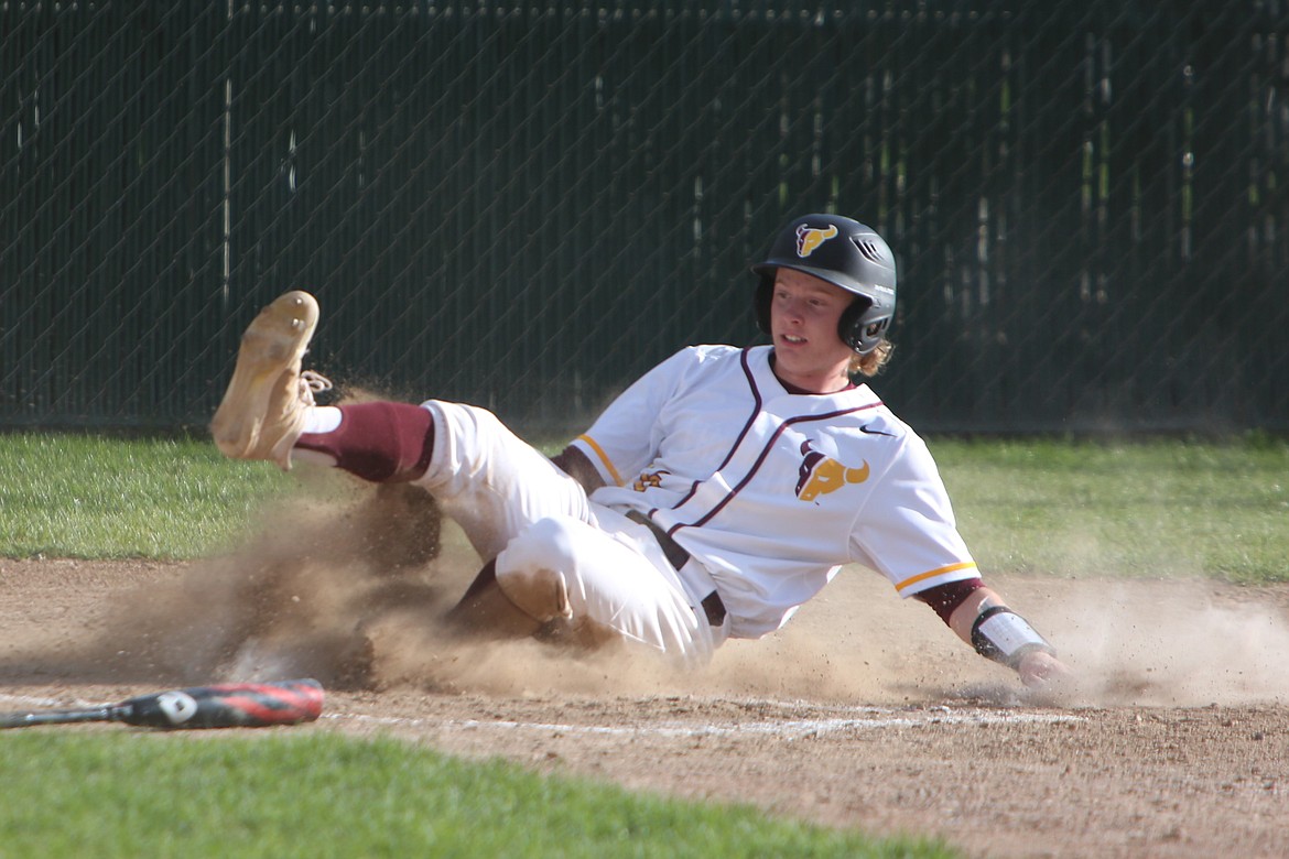 Moses Lake senior Nolan Betz slides across home plate to score Moses Lake’s first run of the game against Davis.