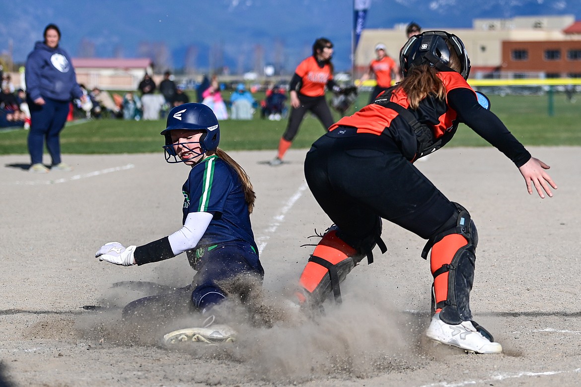 Glacier's Olivia Warriner (10) slides into home ahead of the tag by Flathead catcher Laynee Vessar (12) at Glacier High School on Thursday, April 18. (Casey Kreider/Daily Inter Lake)