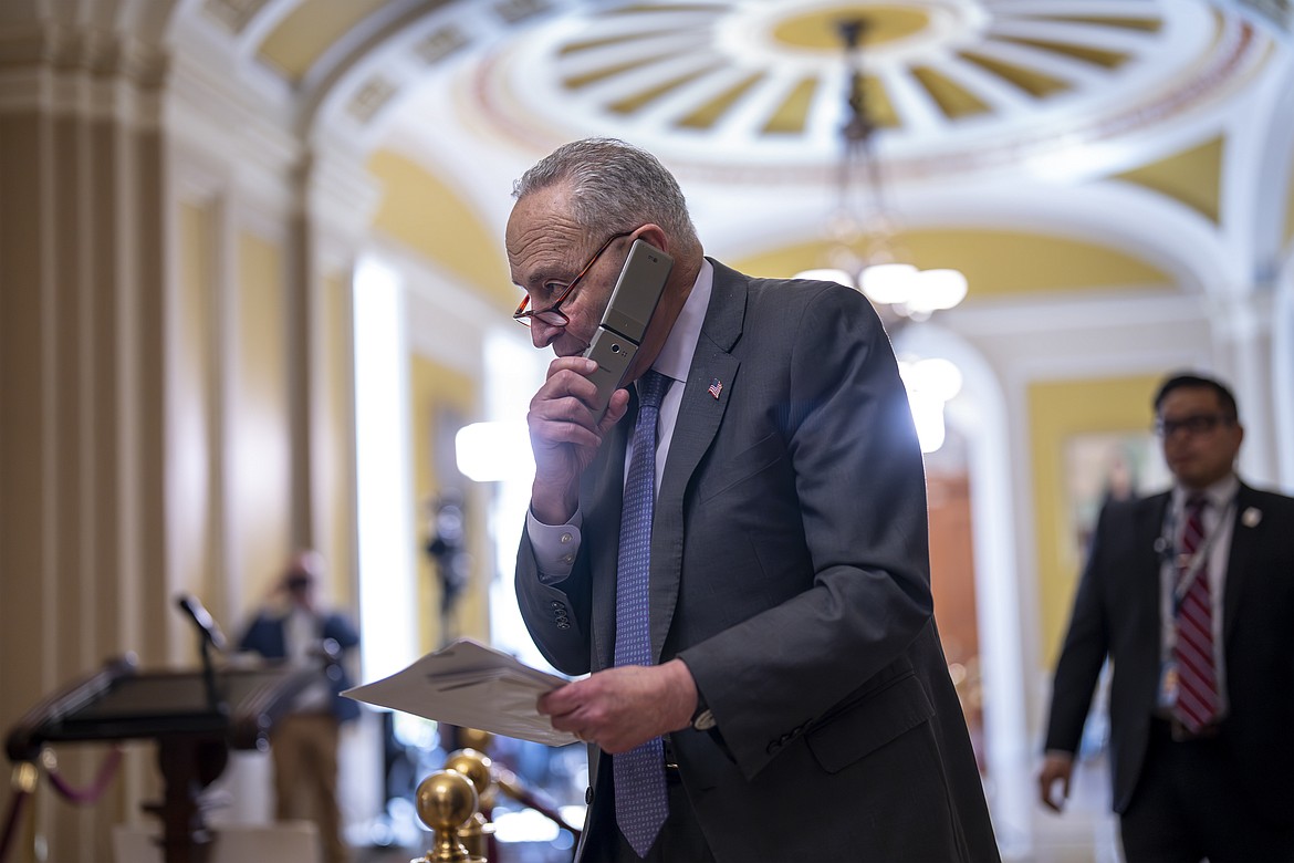 Senate Majority Leader Chuck Schumer, D-N.Y., talks on his phone on the way to a closed-door Democratic strategy session, at the Capitol in Washington, Wednesday, March 20, 2024. (AP Photo/J. Scott Applewhite)