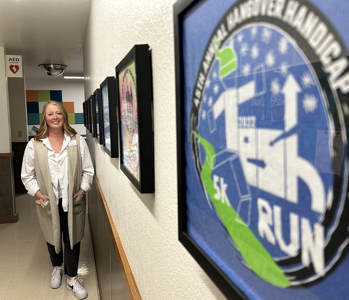 Tesh, Inc. CEO Marcee Hartzell stands in a hallway on Wednesday where past designs of its annual Jan. 1 fun run are on display.