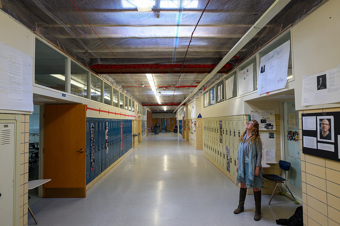 English teacher Jaime Bell eyes the roof over the classroom wing of the Columbia Falls High School earlier this month. (Hungry Horse News)