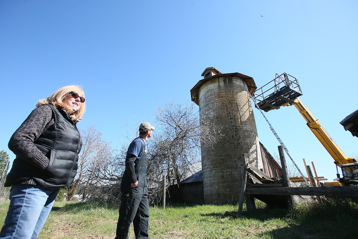 Retired teacher Susan Sloyka and Patrick Record of Record Construction Services are seen Friday morning near the nearly 100-year-old silo on Sloyka's property on South Greensferry Road. Sloyka hired Record to restore the cedar shakes on the silo, which was built by the family that originally homesteaded the land.