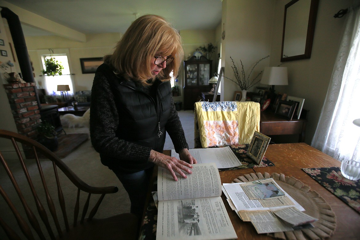 Susan Sloyka goes through historical documents and photos Friday morning while sharing information about the Whitaker family, who homesteaded her property on South Greensferry Road in the early 1900s.