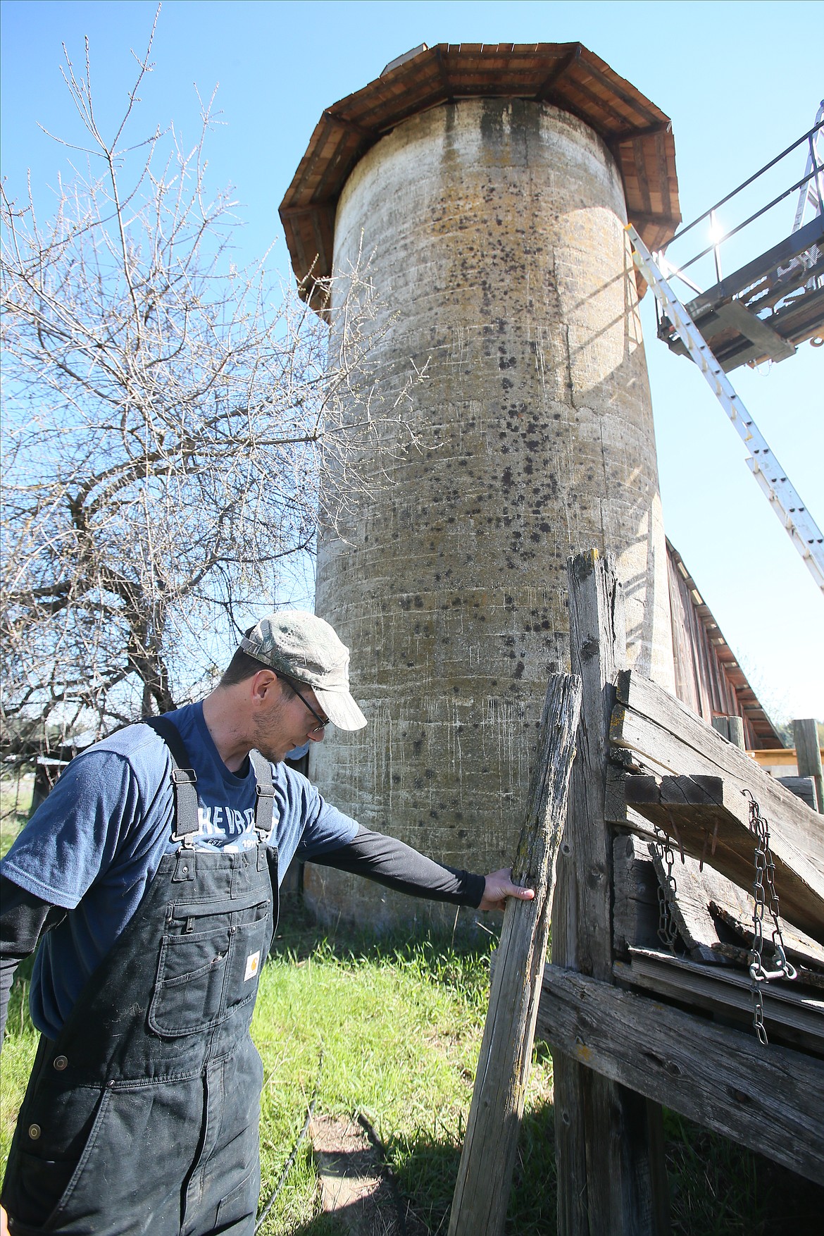 Patrick Record on Friday morning holds up the original piece of wood that was placed on top of Susan Sloyka's grain silo to hold an American flag when the silo was completed nearly 100 years ago.