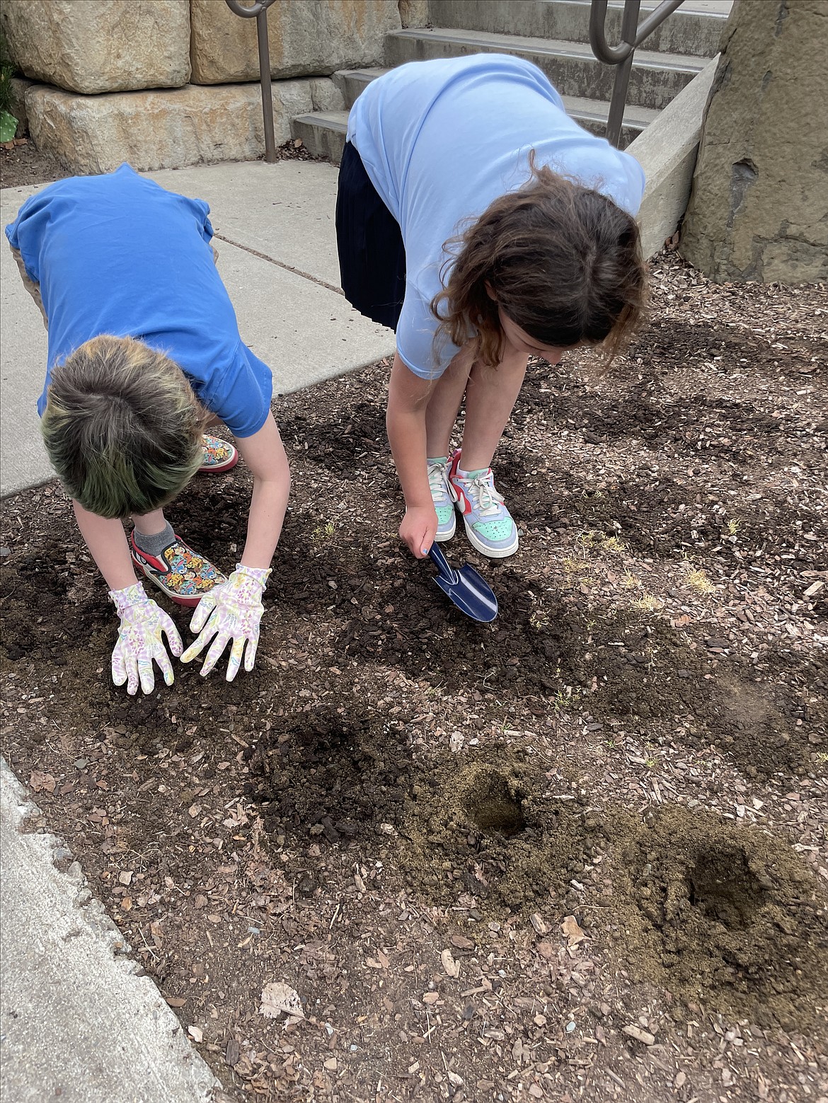 Brighton Shute and Oceana Stewart-Bryan were intent on planting bulbs outside Sorensen Magnet School Tuesday.