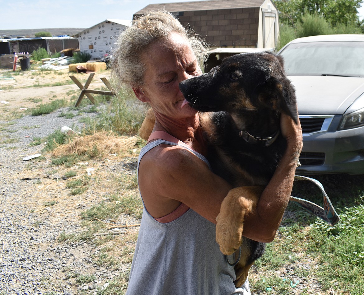 The Rock Bottom Rocker Pet Pantry operator Shawna Kluge gives a cuddle to Vaquero, one of the rescue dogs who boarded at the rescue in summer 2023.