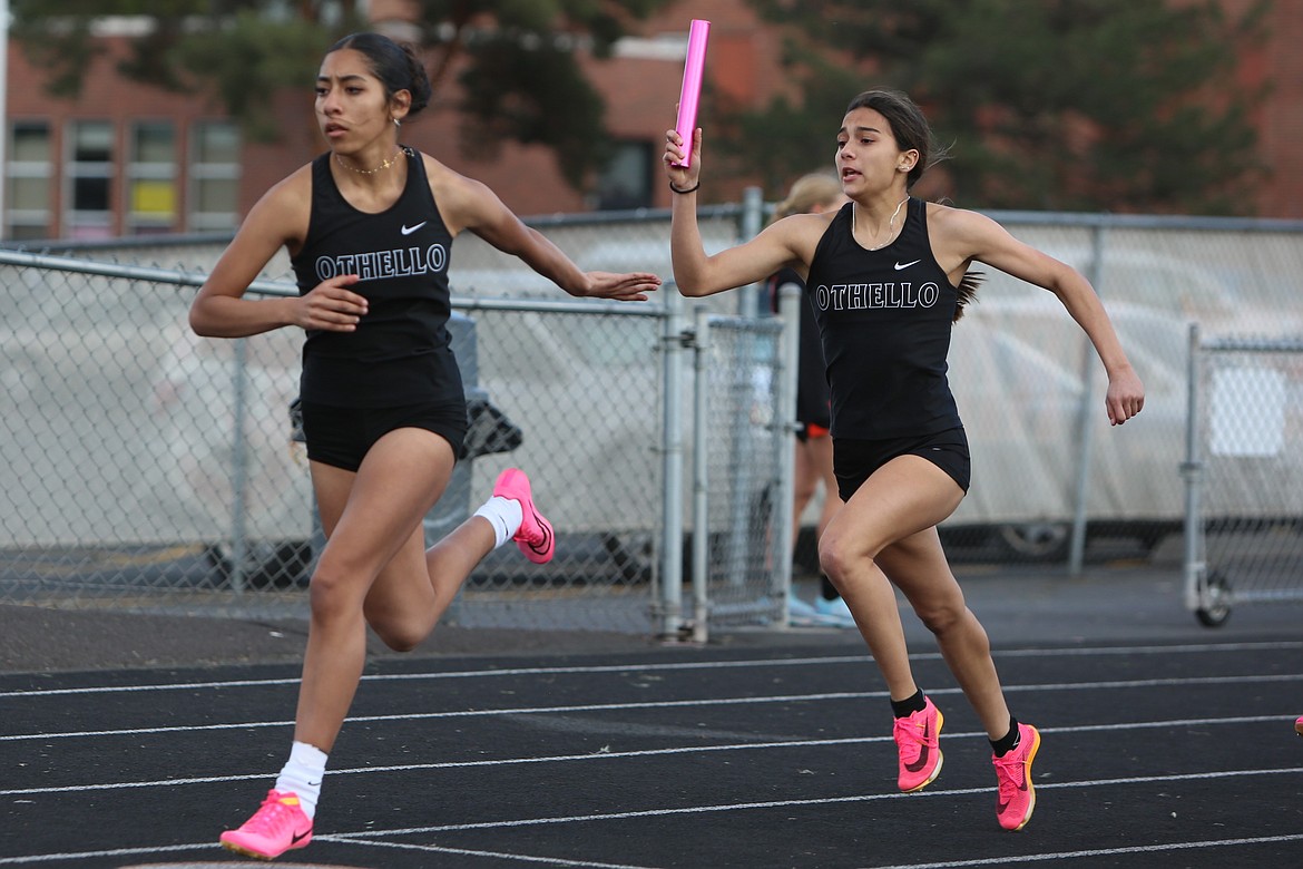 Othello junior Bella Garza, right, passes the baton to freshman Gabriella Dominguez during the 4x100-meter relay at Thursday’s league meet against Ephrata.