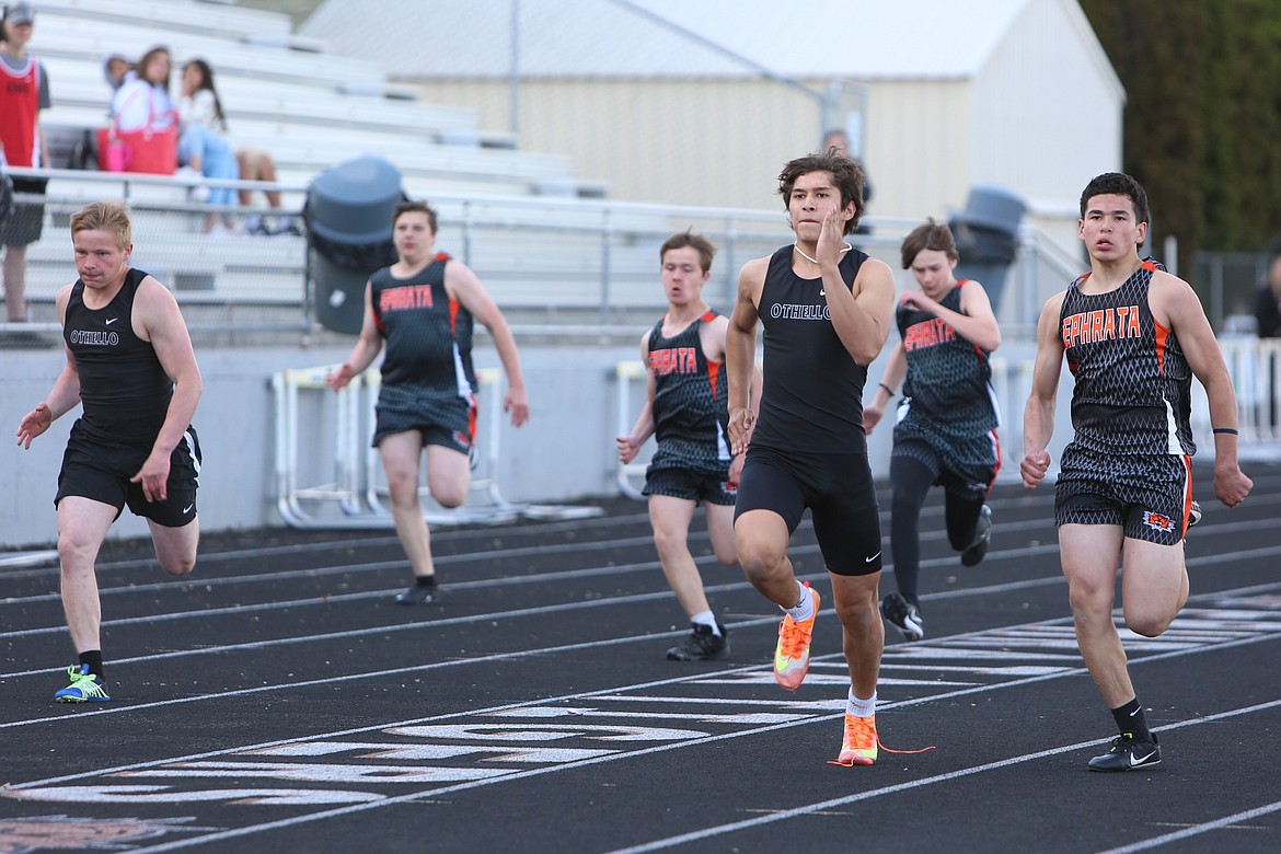 Tiger and Huskies sprinters race down the track during a heat of the boys 100-meter dash on Thursday.