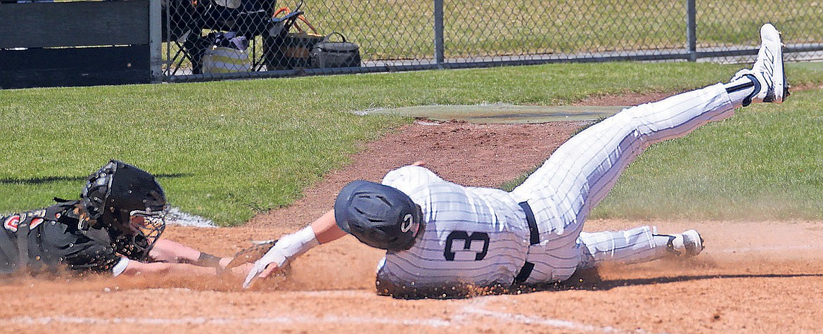 MARK NELKE/Press
Travis Usdrowski (3) of Lake City touches home plate just ahead of the diving tag attempt of Post Falls catcher Marshall Tomlinson during the first game Saturday at Lake City High.