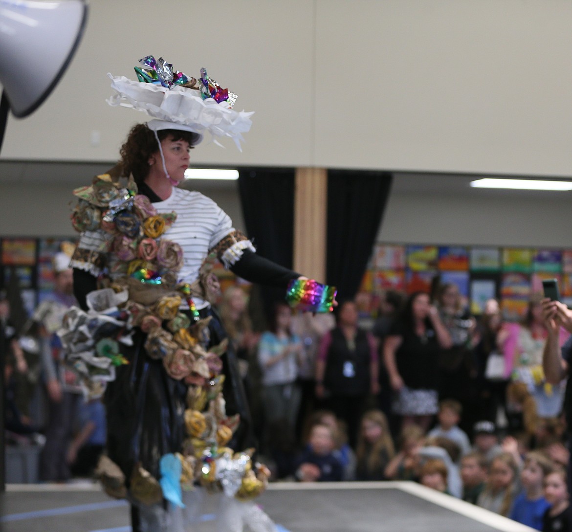 Second-grade teacher Robin Curtis struts in a colorfully upcycled dress and hat Monday during the Trashin' Fashion Show at Hayden Canyon Charter.