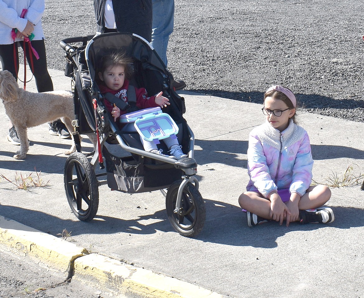 Two-year-old Lottie Suarez, left, and her sister Everleigh Suarez, 8, wait on Third Avenue for their 7-year-old brother Daxton Suarez, who plays for the A’s, to pass by in the Moses Lake Youth Parade Saturday morning.