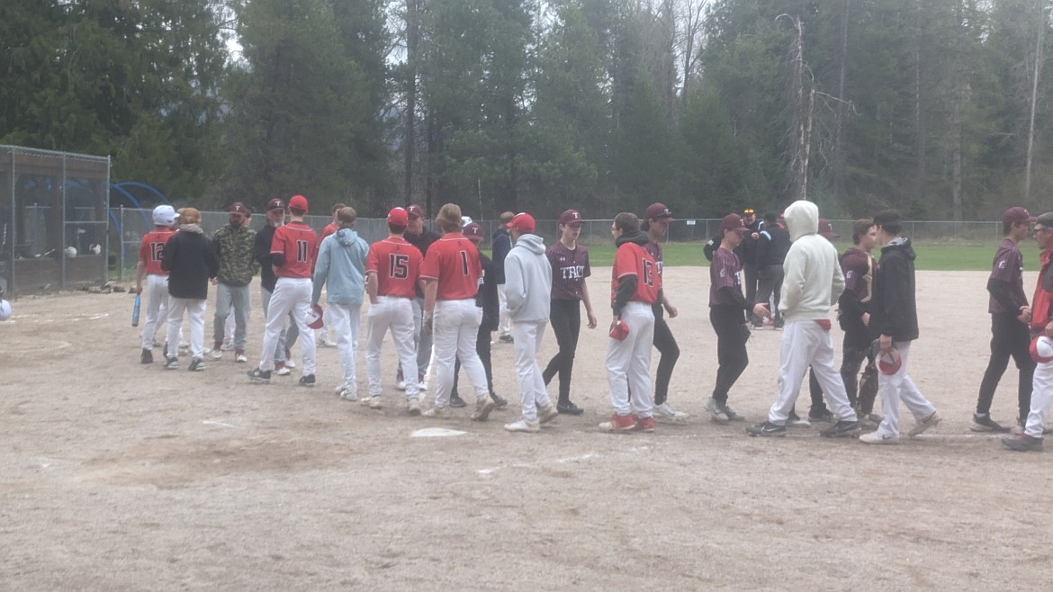 Players from Noxon and Troy (maroon jerseys) engage in sportsmanship following their game last week in Noxon, won by the Red Devils 13-2 on a foggy day. (Photo by Krya Ashlock)