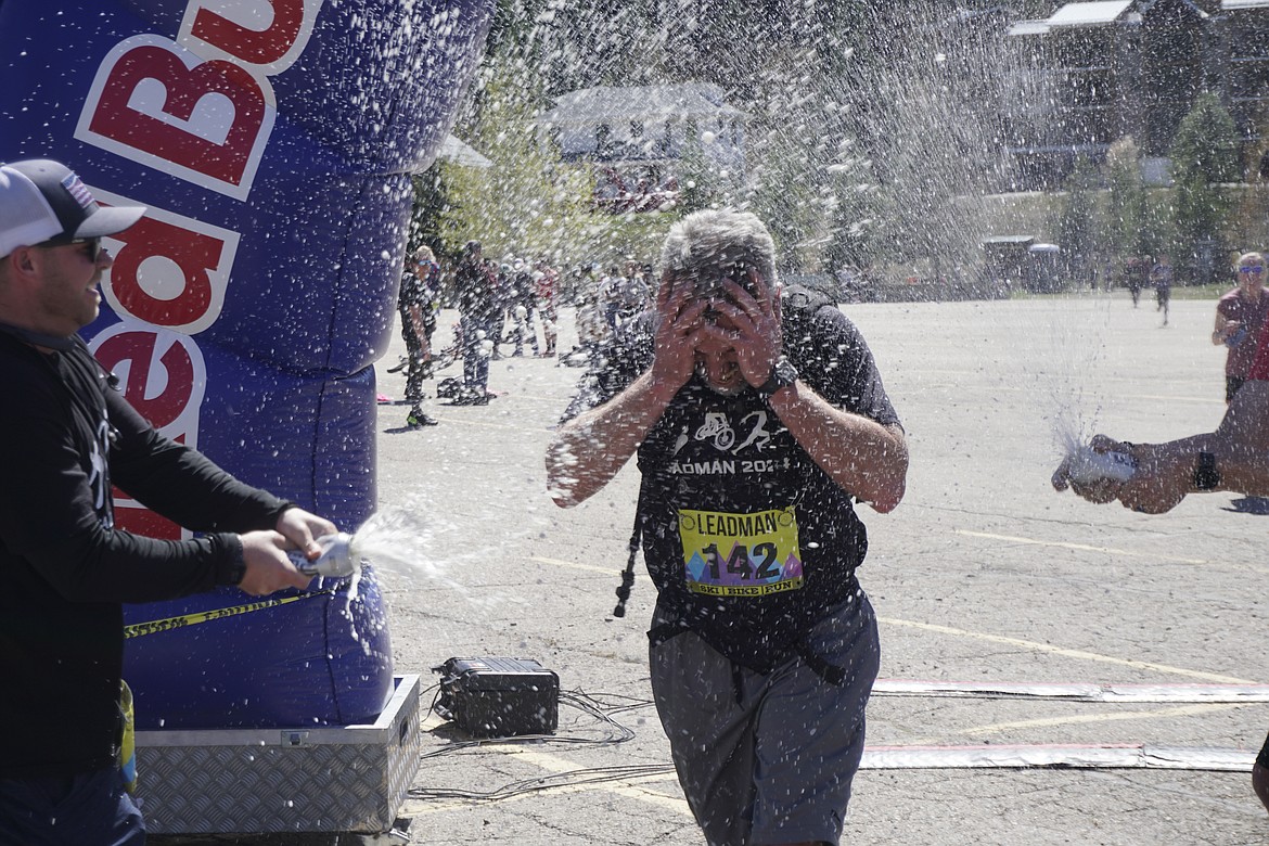 Trevor Taylor, of Hayden, is sprayed at the finish line of the Leadman Triathlon.