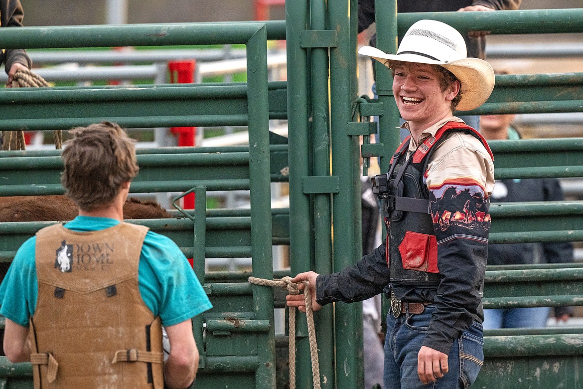 Korbin Baldwin holds the chute gate while talking with one of the riders at Baldwin Bucking Bulls Friday, April 12.