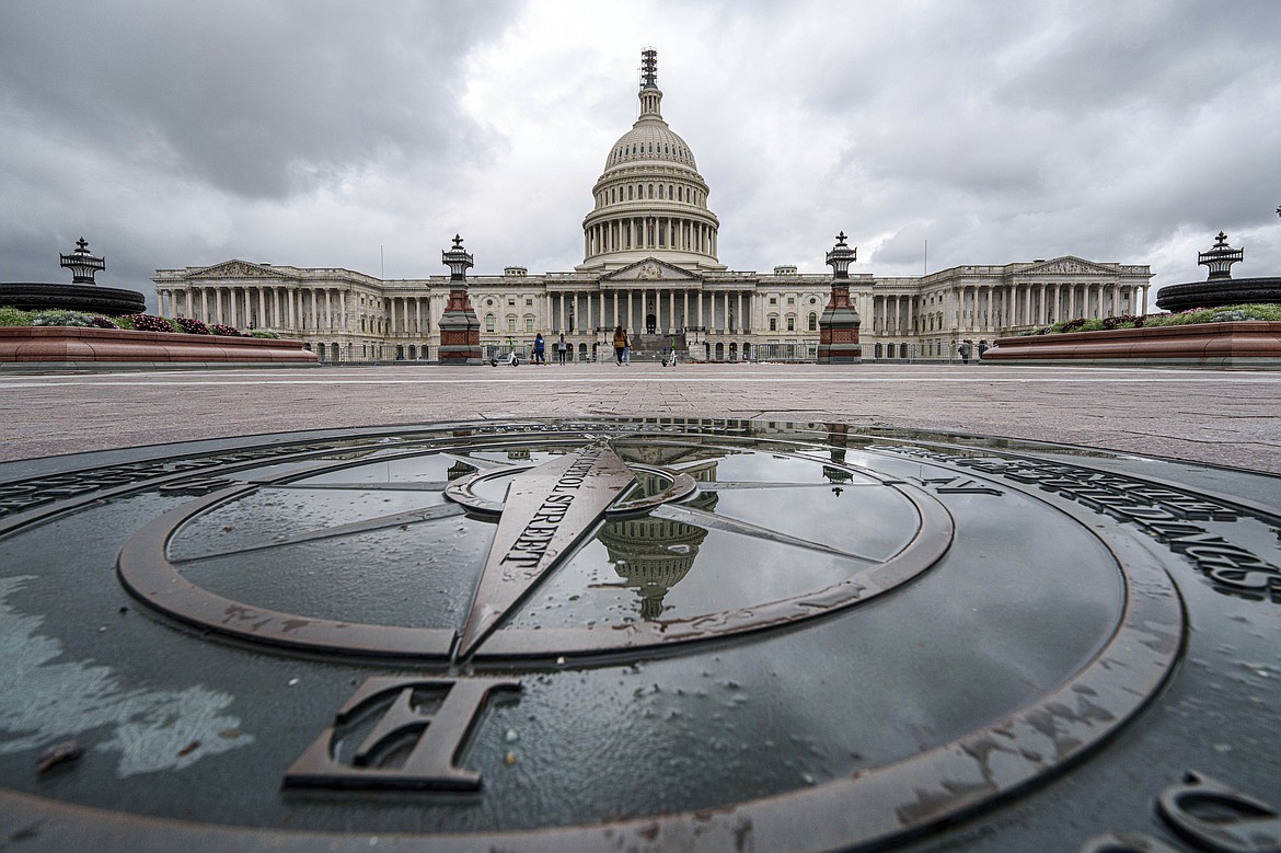 The U.S. Capitol Dome is reflected in a rain puddle on the compass star on the east side of the building, Sunday, Sept. 24, 2023. (AP Photo/J. David Ake)