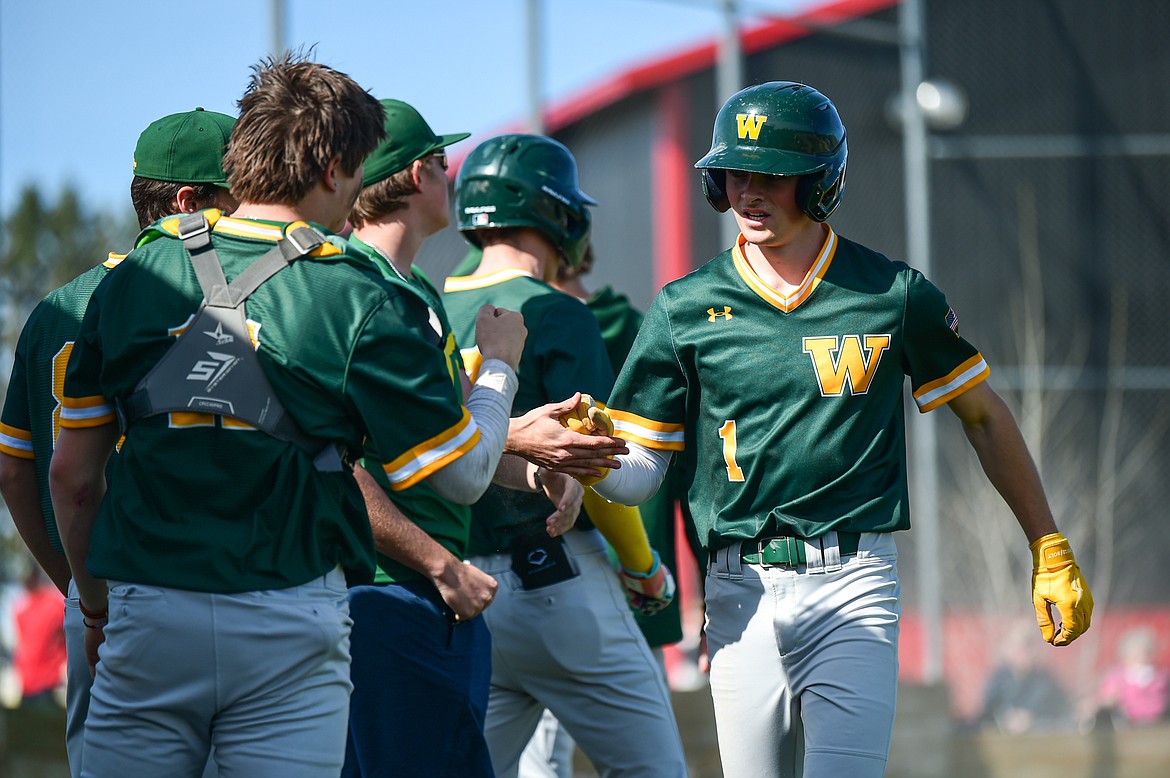 Whitefish's Ryan Conklin (1) is congratulated by teammates after scoring a run against Bigfork at ABS Park in Evergreen on Tuesday, April 23. (Casey Kreider/Daily Inter Lake)
