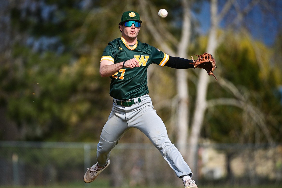Whitefish third baseman Michael Miller (27) throws to first after charging a grounder against Bigfork at ABS Park in Evergreen on Tuesday, April 23. (Casey Kreider/Daily Inter Lake)