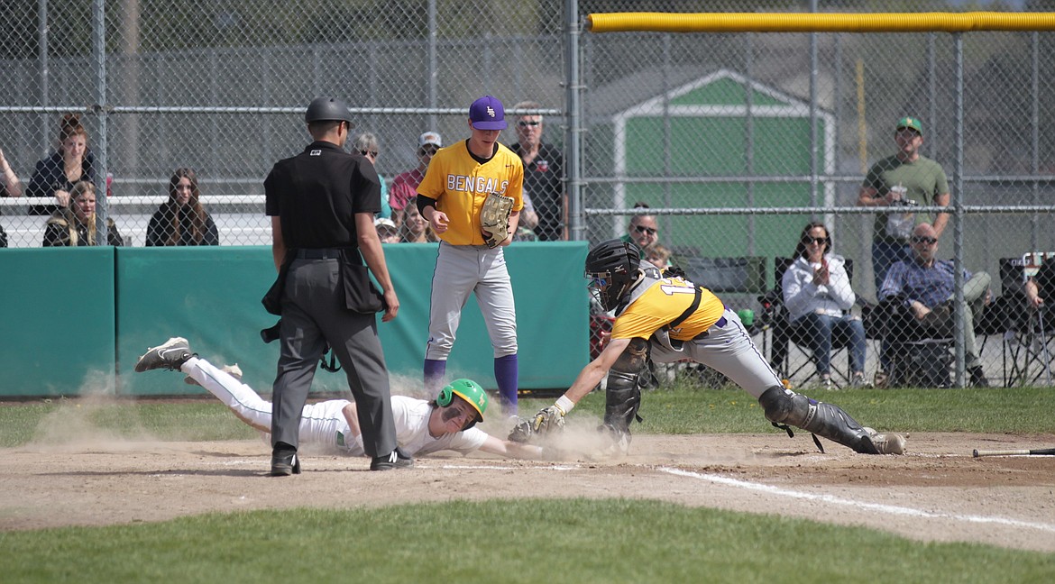 MARK NELKE/Press
After missing the plate on the initial slide, Lakeland sophomore Jace Taylor dives back to touch home plate, just ahead of the tag from Lewiston catcher River Stamper on Tuesday in the first game at Gorton Field in Rathdrum. Looking on is Lewiston pitcher Zack Bambacigno.