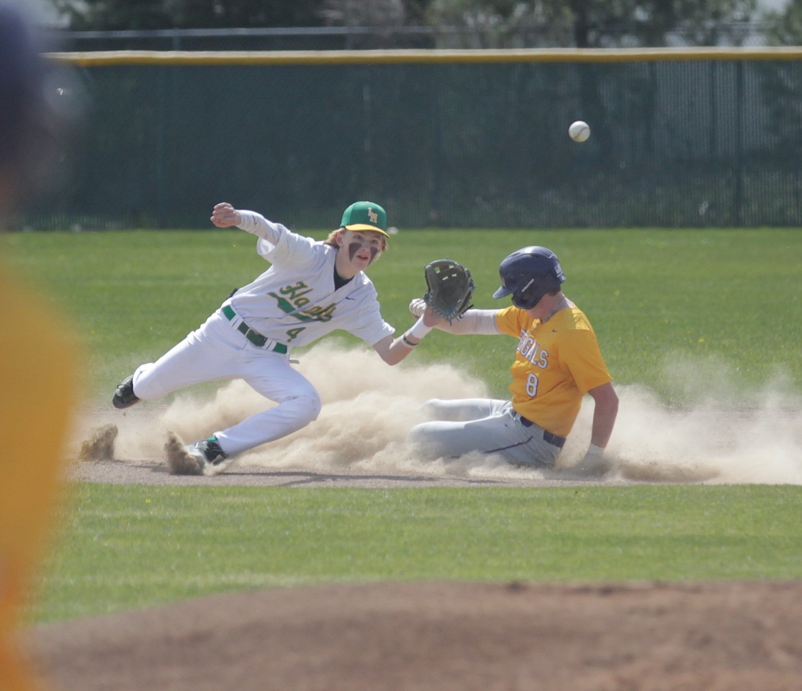 MARK NELKE/Press
Lakeland sophomore second baseman Jake Larcher (4) awaits the throw from the catcher as Tucker Green of Lewiston slides in safely during the first game Tuesday at Gorton Field in Rathdrum.