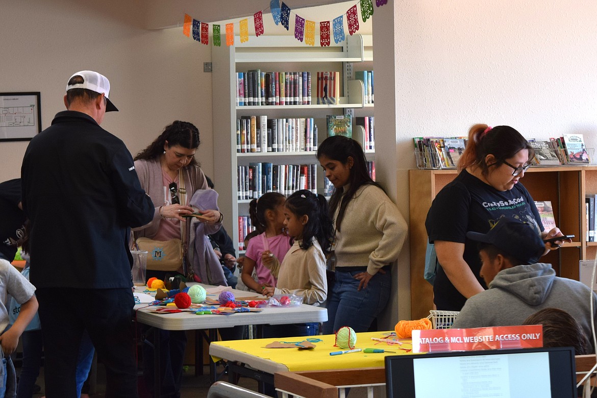 Parents and children work at one of the arts and crafts tables at Saturday’s Day of the Children event at the Othello Public Library