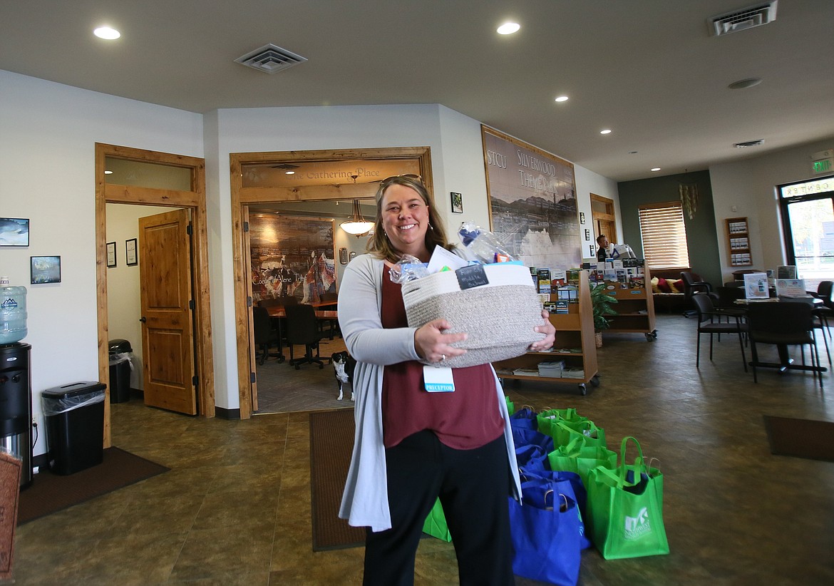 Camey Yeager, manager of student services and employee health for Northwest Specialty Hospital, hauls a gift basket out to a vehicle Tuesday morning at the Post Falls Chamber. She and several others delivered gifts to schools throughout Post Falls to say "Thank you" to teachers and staff.