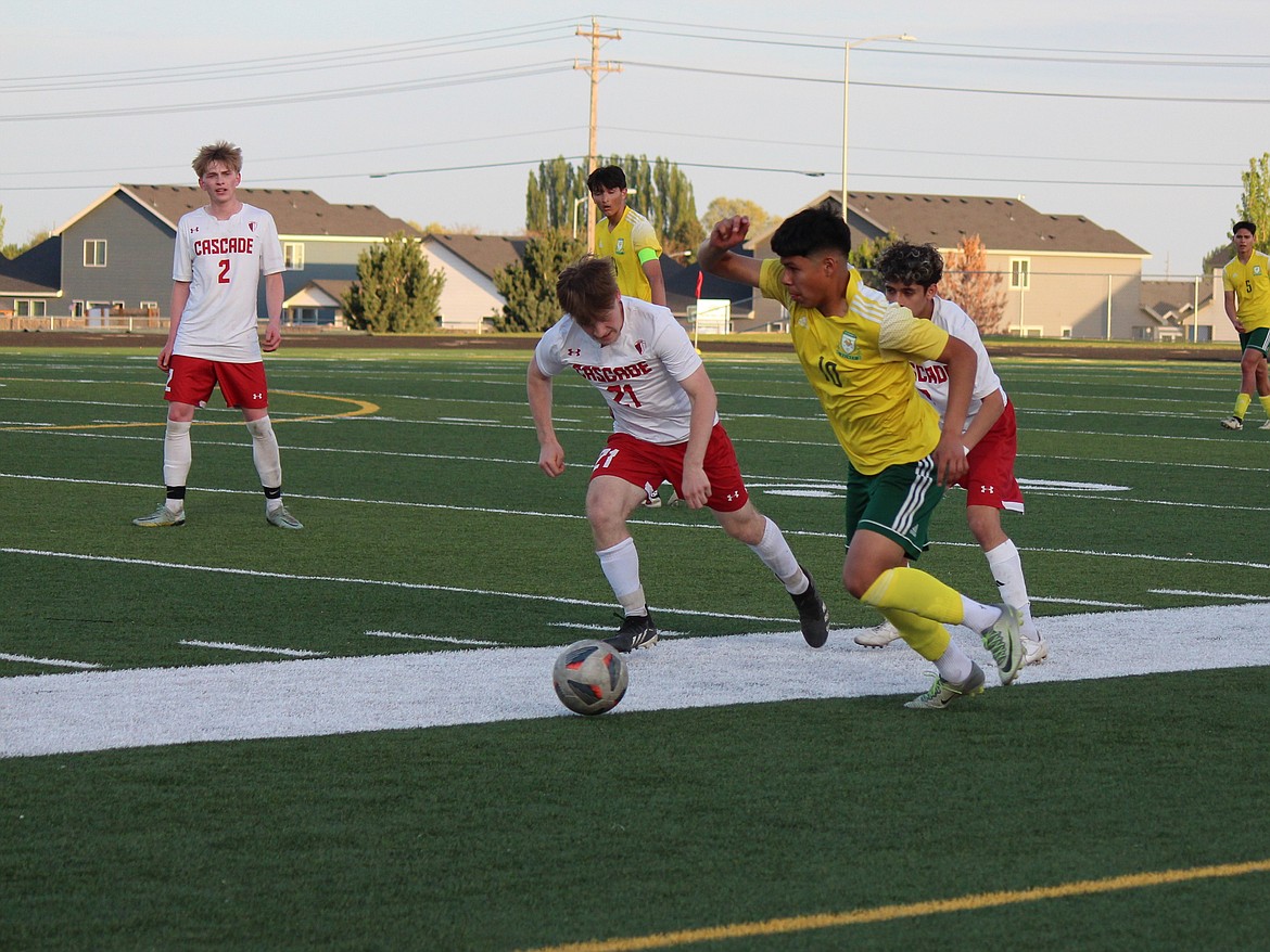 Lester Chacaj (10), Quincy midfielder, fights a pair of Cascade midfielders for the ball.