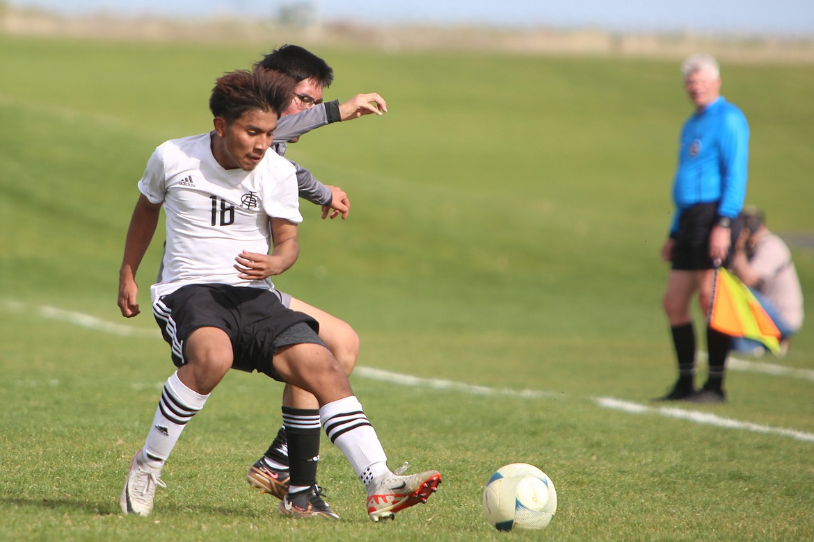 Royal sophomore Victor Aquino, in white, rushes in to take possession of a loose ball in the second half against Royal on Tuesday.