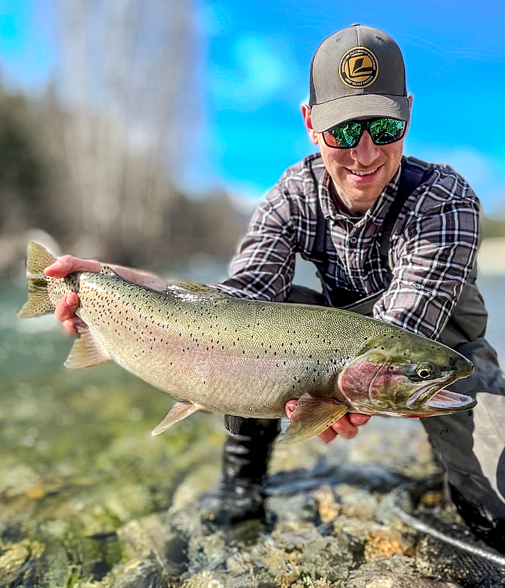 Daniel Whitesitt hoists a trophy Westslope Cutthroat Trout from the Clark Fork River. The 25-inch trout set a new "catch-and-release" state record.