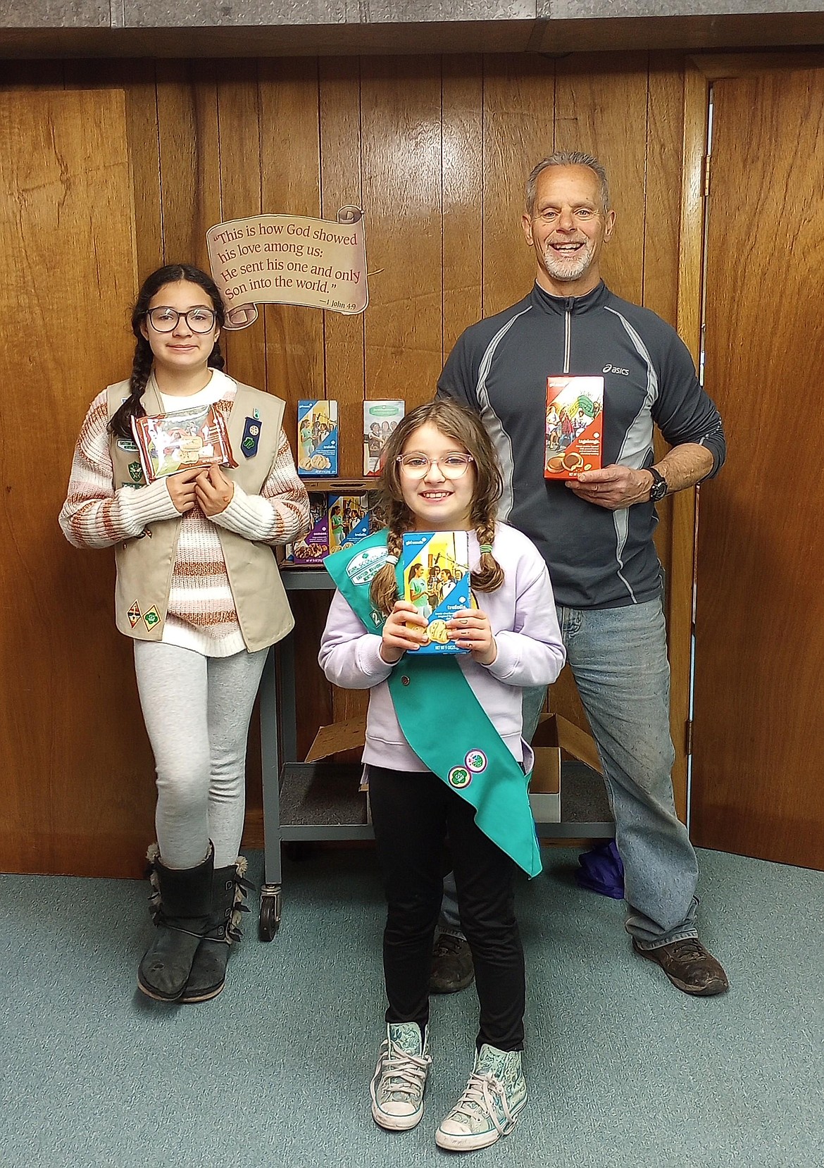 Girl scouts Lucille Corona and Abigail Corona pose with Wallace Food Bank president Michael Hoffman.