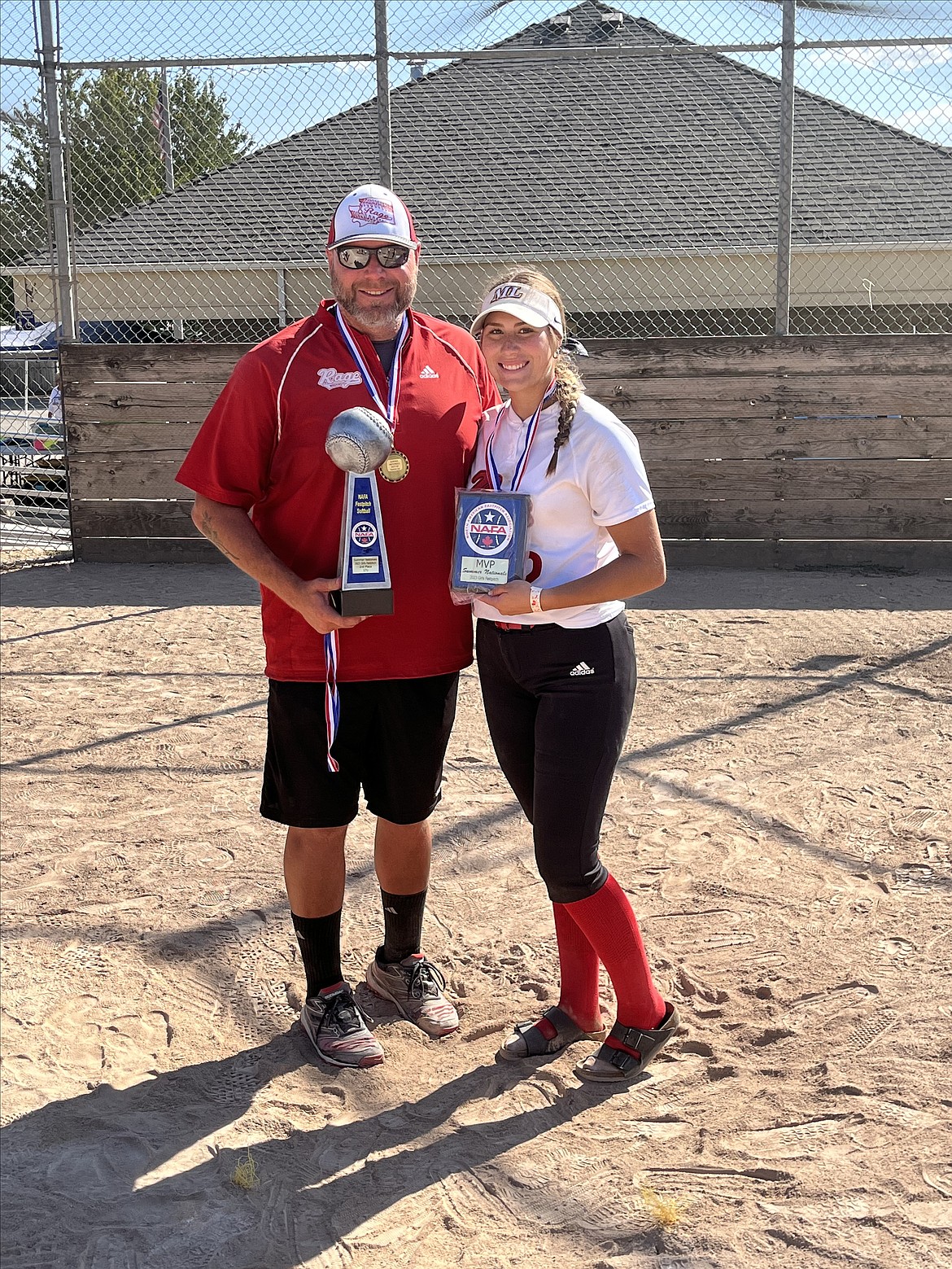Paige Richardson, right, and her dad Bob Richardson display Paige’s MVP and the team’s runner-up trophy from the 2023 national softball championship tournament.