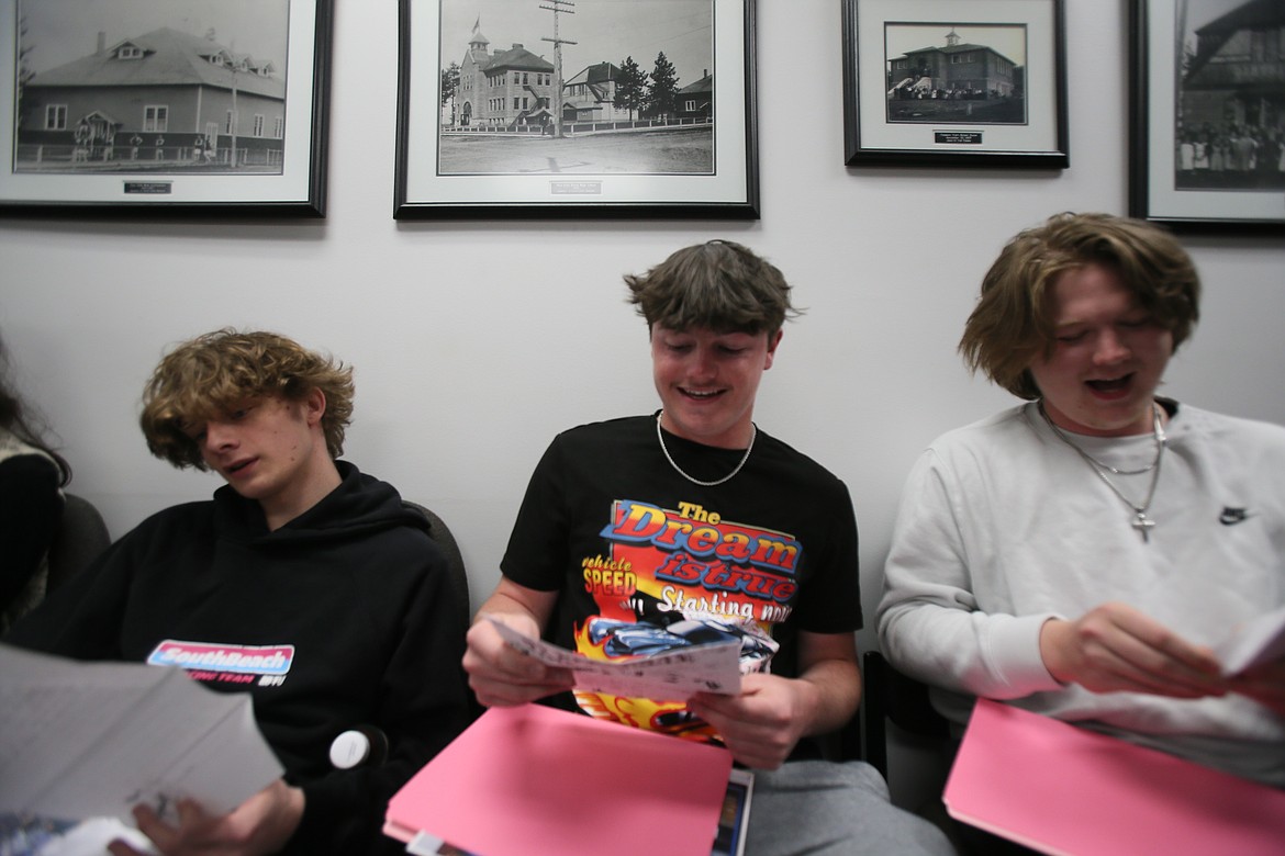 From left, Post Falls High seniors Logan Blettner, Tyler French and Aiden Tomlinson can't help but smile Thursday morning as they read letters written by their fifth grade selves when they were among the first students at Greensferry Elementary School.