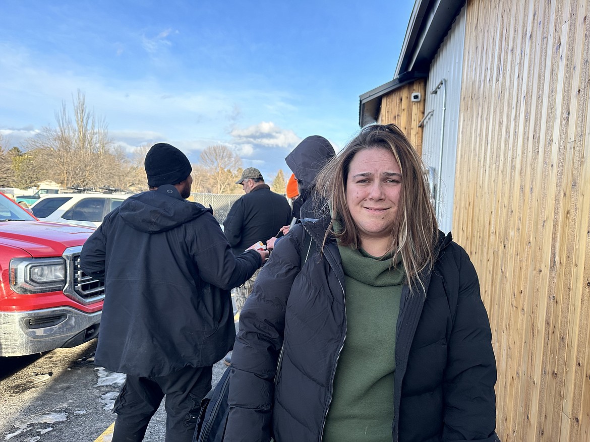 Tashya Evans waits outside the Flathead Warming Center, a low-barrier shelter in Kalispell on March 5, 2024. Evans had just finished work in time to join the line for a bed that evening. (Aaron Bolton/MTPR)