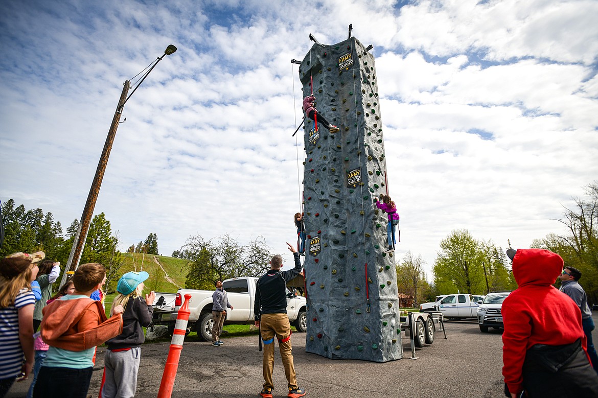 Third-grade students scale a climbing wall at a Montana Army National Guard station at the Arbor Day celebration at Lawrence Park on Friday, April 26. (Casey Kreider/Daily Inter Lake)