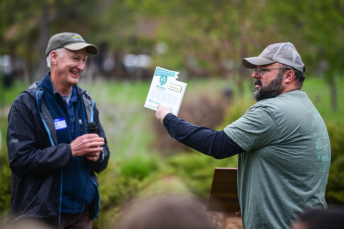 Fred Bicha, right, Parks Superintendent with Kalispell Parks & Recreation, receives the Tree City USA Growth Award on behalf of the city from Greg Poncin, with the Montana DNRC, at the Arbor Day celebration at Lawrence Park on Friday, April 26. (Casey Kreider/Daily Inter Lake)