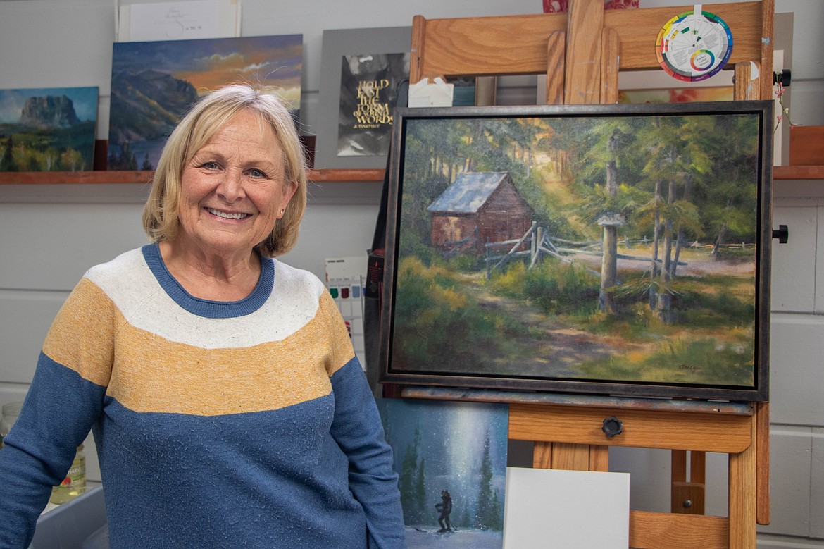 Gini Ogle, a former resident of the Artist Wilderness Connection program, is seen next to a painting she completed during her residency in the Bob Marshall Wilderness. (Kate Heston/Daily Inter Lake)