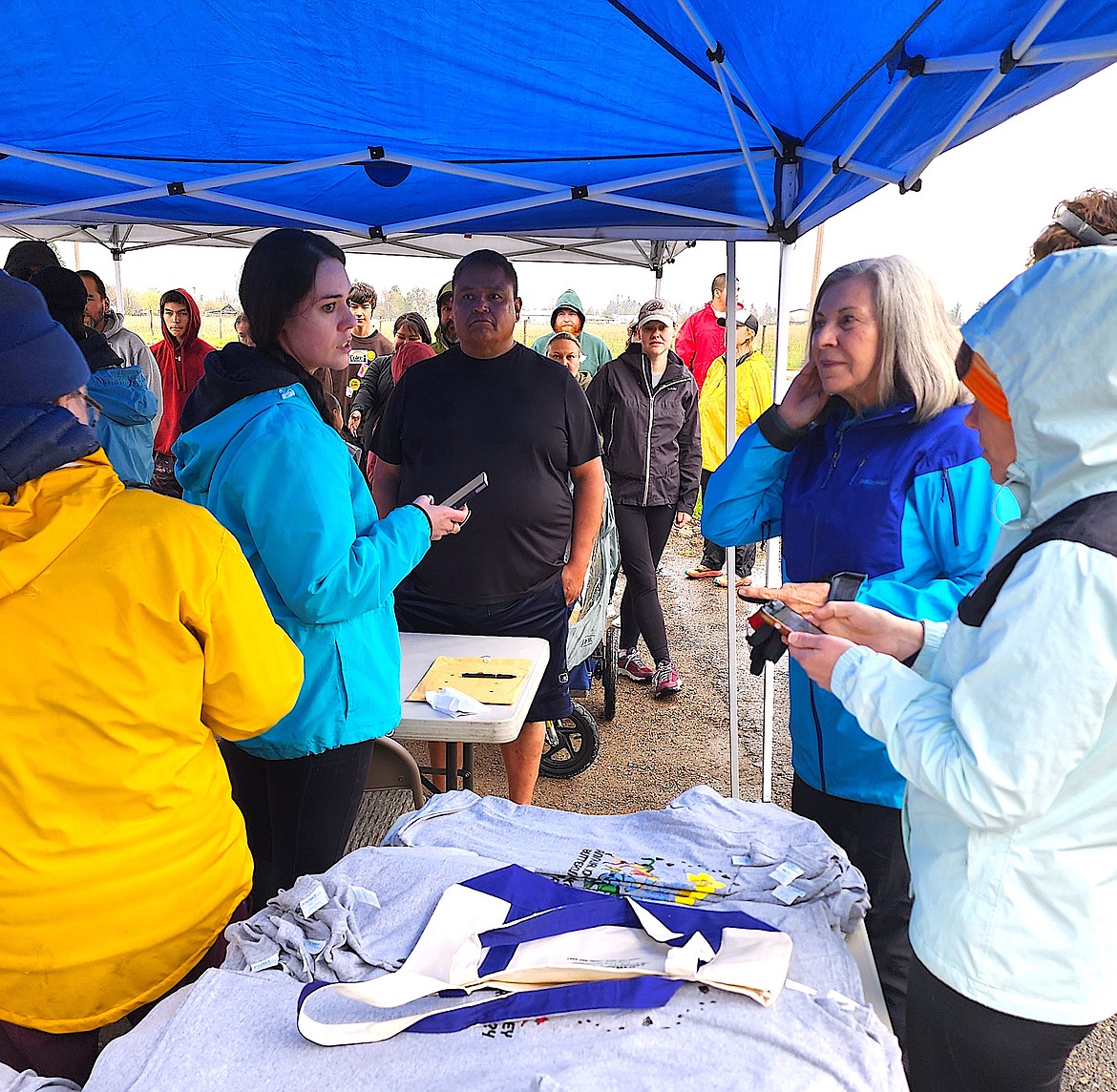 The check-in tent at the Arlee Buttercup Run was bustling Saturday morning. Dr. Samantha Morigeau, in blue coat, and her cohorts at Tribal Health helped revive this year's run. (Berl Tiskus/Leader)