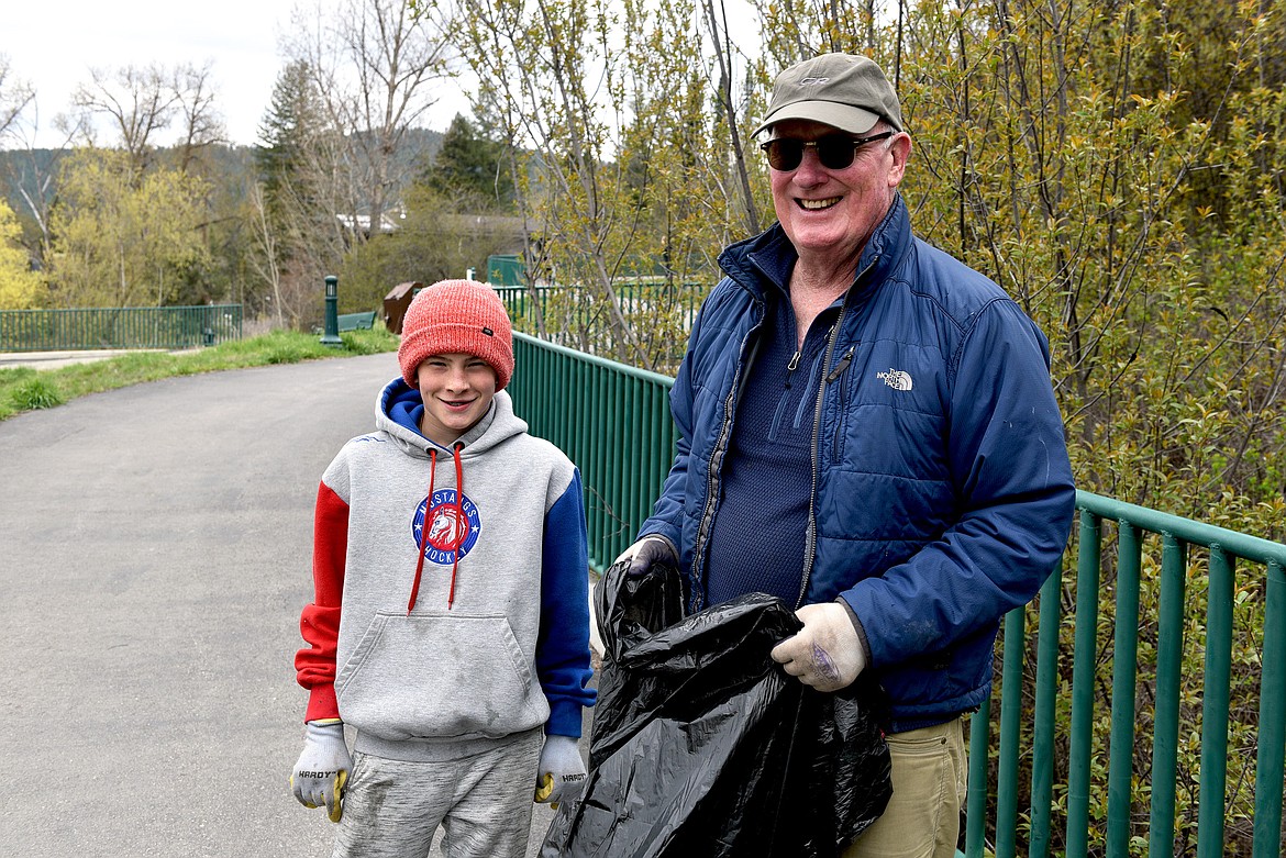 “You can call this one ‘Gus and Grandpa,’.” Gus was eager to scramble through the underbrush to untangle trash along the river by Roundhouse Park during the annual Clean the Fish event (Kelsey Evans/Pilot).