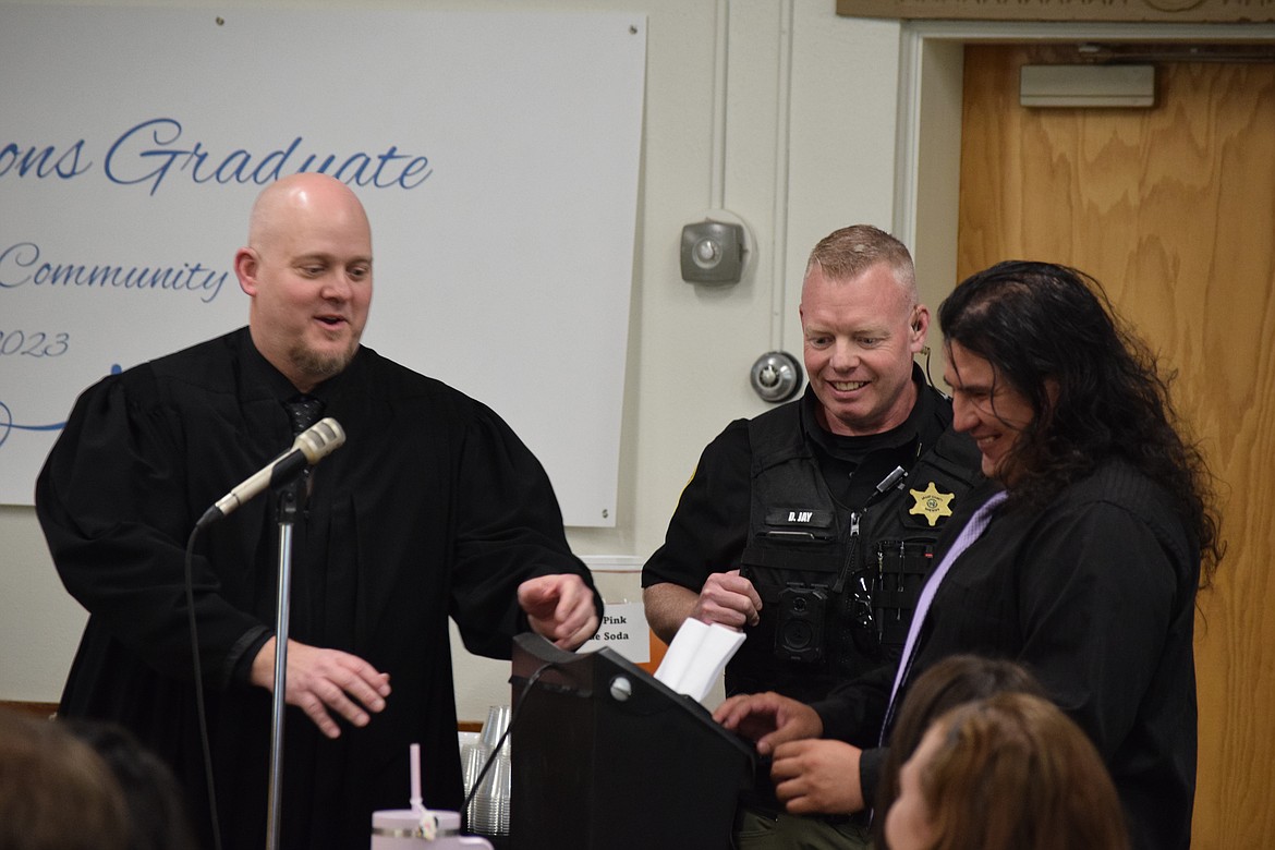 Judge Brian Gwinn, left, and Lt. Derek Jay, center, watch as Eddie Navarro shreds a copy of the paperwork that documented crimes Navarro had been charged with. After completing the Community Court program which involved getting clean, working toward life goals, learning to make solid decisions and growing as an individual, Gwinn said Navarro has turned into a leader and an example of the good Community Court can accomplish.