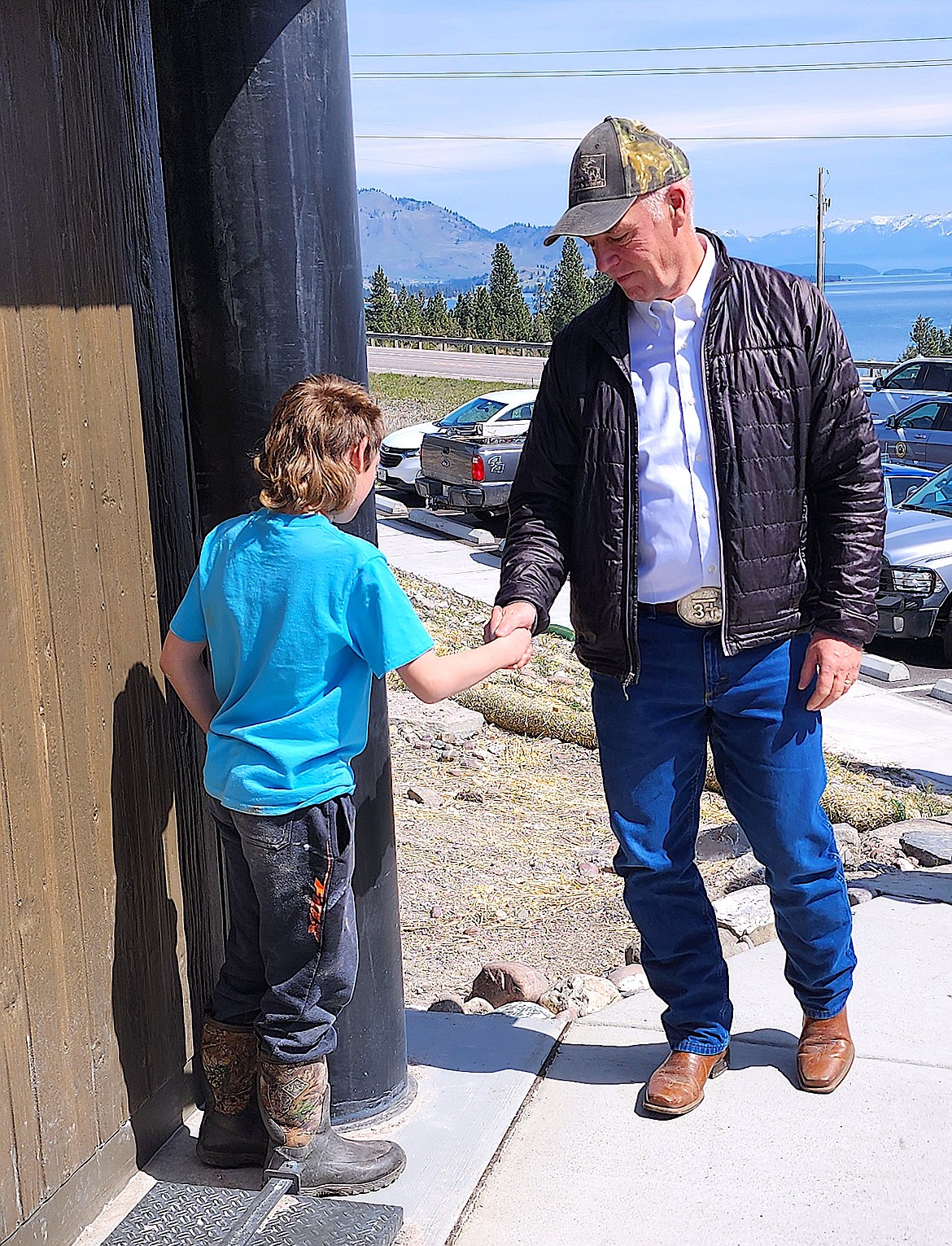 Governor Greg Gianforte shakes hands with a Dayton Elementary School student at the formal opening of the Big Arm Public Archery Range. (Berl Tiskus/Leader)