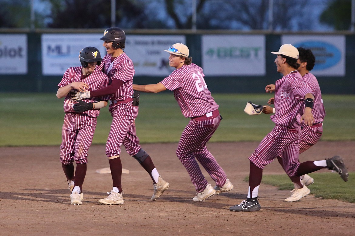 Moses Lake players celebrate with junior Adrian Martinez, left, after Friday’s walk-off win over Wenatchee. Martinez put the ball in play with a bunt in the bottom of the ninth, which allowed senior Nolan Crawford to score off a Wenatchee error.